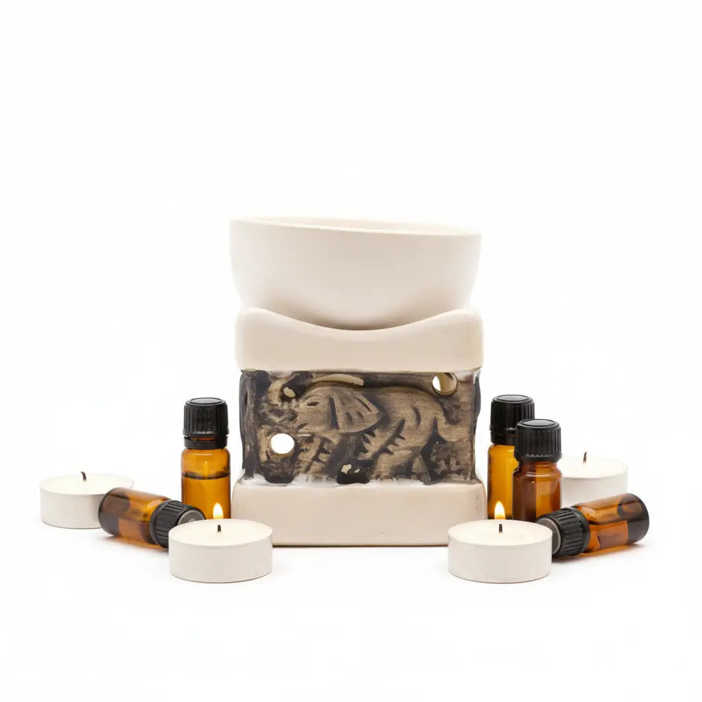 Elefante blanco cerámico con velas y aceites - fondo blanco