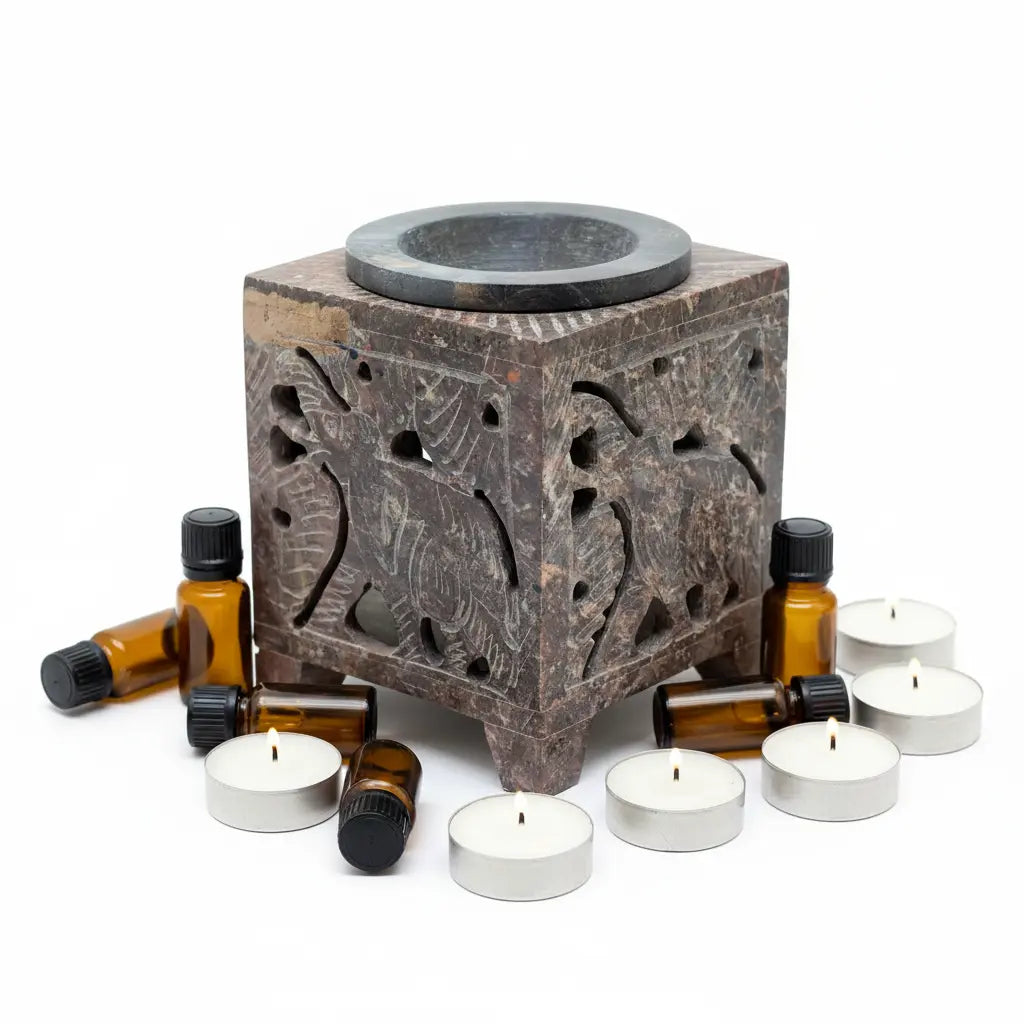 Quemador esteatita elefante con velas y aceites - fondo blanco