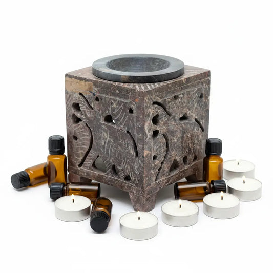 Quemador esteatita elefante con velas y aceites - fondo blanco